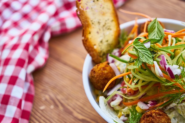 veganer salat in weißer schüssel mit brot