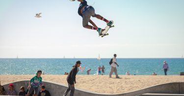 ein skate-platz am strand in dem drei skater fahren und springen