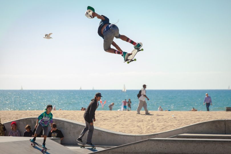 ein skate-platz am strand in dem drei skater fahren und springen