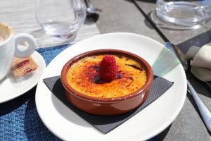 Katalanische Creme in Tonschüssel mit Himbeere in der Mitte