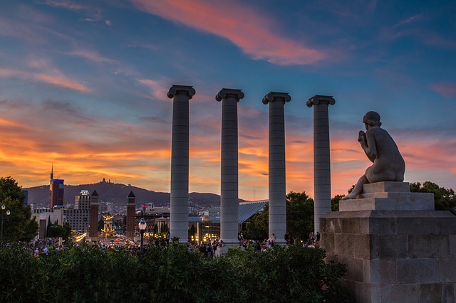 Die vier Säulen des Augustus Tempels bei Sonnenuntergang, davor ist eine weisse Statue zu sehen