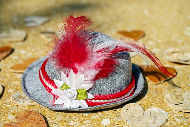 traditioneller trachtenhut mit roten und weißen federn