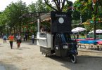ein schwarzer Mini-Food-Truck der in einem Park steht