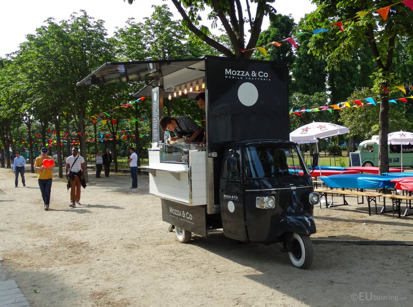 ein schwarzer Mini-Food-Truck der in einem Park steht