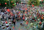 Platz mit vielen tanzenden Menschen Luftschlangen und Ballons