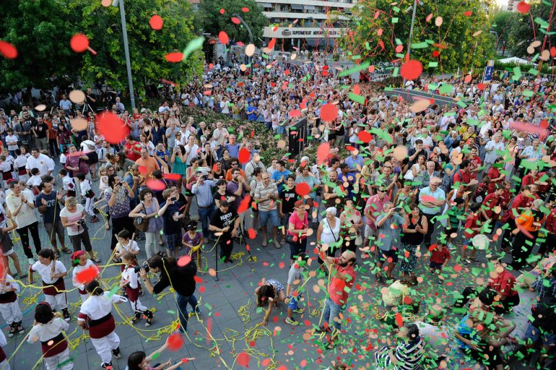 Platz mit vielen tanzenden Menschen Luftschlangen und Ballons