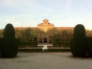 Das Parlament von Katalonien mit Bäumen und einer rundgestutzten Hecke davor