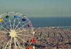 Aussicht auf Barcelona mit dem bunten Riesenrad des Tibidabo Vergnügungsparks
