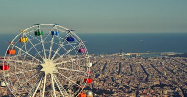 Aussicht auf Barcelona mit dem bunten Riesenrad des Tibidabo Vergnügungsparks