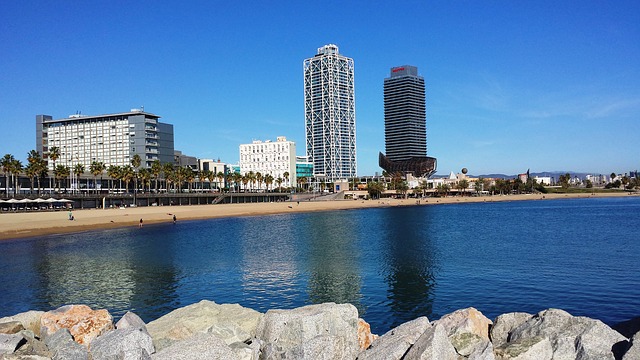 Aussicht von den Felsen auf den leeren Strand Barcelonas mit tiefblauem Meer 