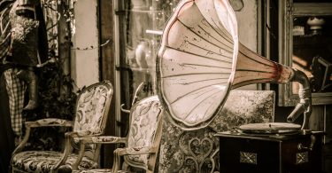 eine Ecke eines Antiquitätenladens auf dem ein alter Plattenspieler und zwei vintage Sessel zu sehen sind