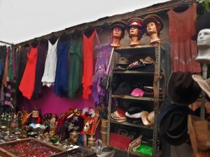 Flohmarktstand mit bunten Kleidern und Hüten aller Art