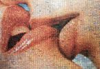 ein Wandmosaik auf dem zwei küssende Münder zu sehen sind