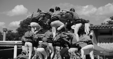 ein schwarz-weiss Foto von einer Bastlers Gruppe die gerade eine Menschenpyramide bilden