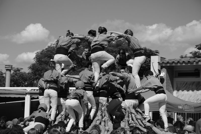 ein schwarz-weiss Foto von einer Bastlers Gruppe die gerade eine Menschenpyramide bilden