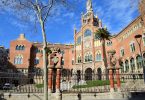 Frontaufnahme eines der Gebäude des Hospital de Sant Pau, es ist eingeweiht und hat große Treppen vor dem Haupteingang