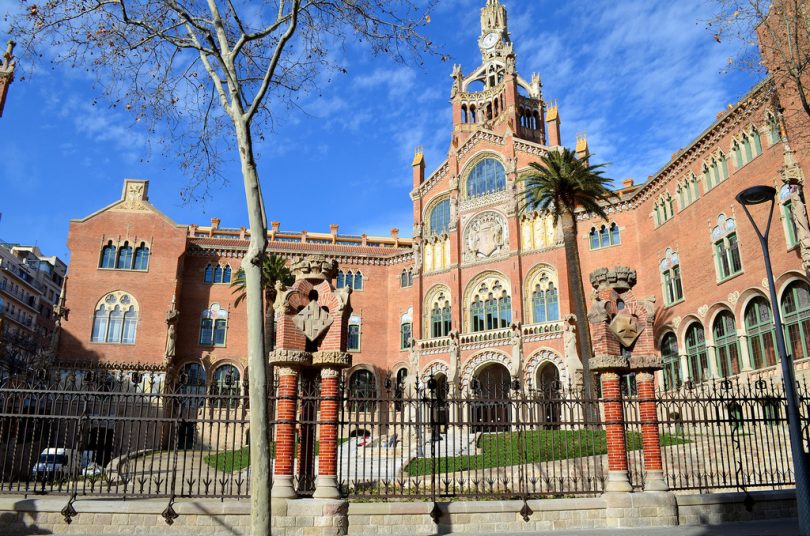 Frontaufnahme eines der Gebäude des Hospital de Sant Pau, es ist eingeweiht und hat große Treppen vor dem Haupteingang