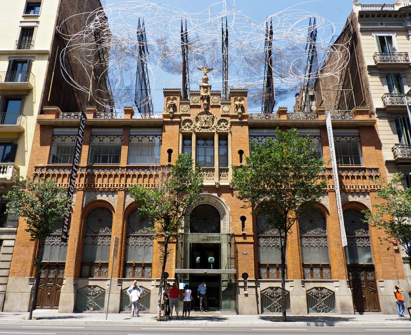 Frontaufnahme des Gebäudes in der sich die Stiftung Antonio Tàpies befindet, Backsteinhaus mit hohen oben runden Fenstern
