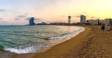 Abschnitt des Sandstrands der Barceloneta mit dem Hotel-W am Schluss