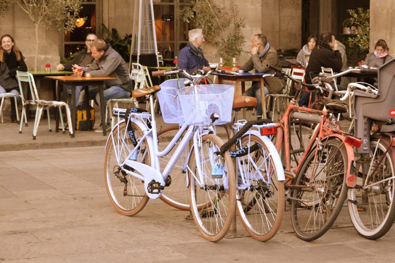 mehrere Fahrräder die vor einer Terrasse eines Café geparkt sind