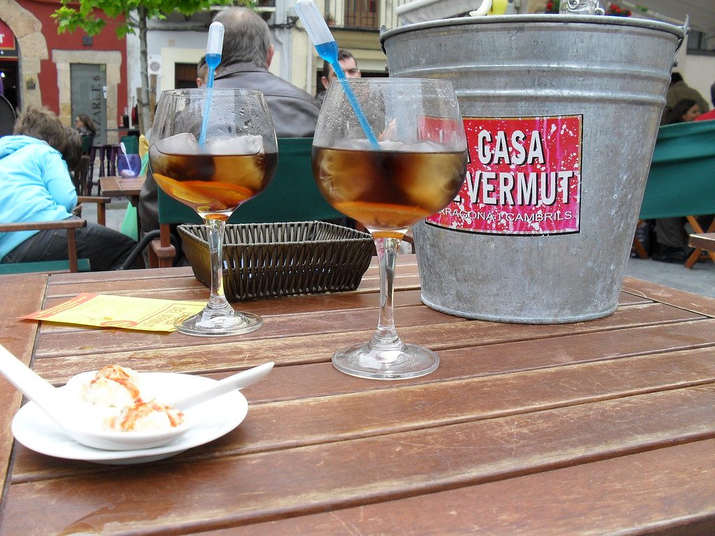 Nahaufnahme eines Tisches auf einer Terrasse in Barcelona mit zwei großen Gläsern mit Wermut und Eis gefüllt