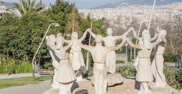 statue namens monument a la sardana, Frauen und Männer die einen Kreis bilden und sich an den Händen halten und tanzen