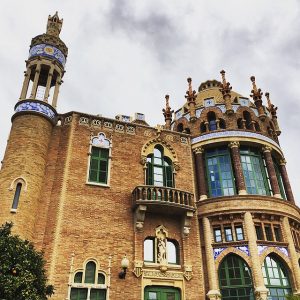 Seitenansicht des Gebäudes, links ein hoher schmaler Aussichtsturm in der Mitte ein kleiner Balkon und rechts eine vergoldete Kuppel 