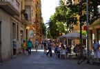 Fussgängerzone in Poble Sec , Terrasse eines Cafés mit weisen Sonnenschirm