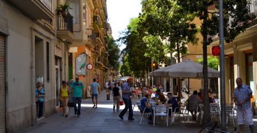 Fussgängerzone in Poble Sec , Terrasse eines Cafés mit weisen Sonnenschirm