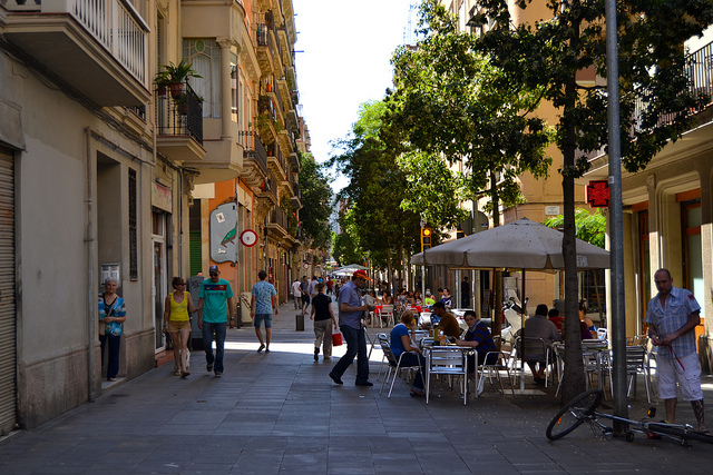 Fussgängerzone in Poble Sec , Terrasse eines Cafés mit weisen Sonnenschirm