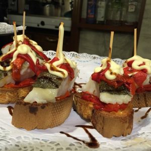 Teller mit fünf Pintxos aus Baguette, Kabeljau und gebratene Paprika