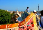 Leute auf den bunten Bänken die die Aussicht auf Barcelona geniessen