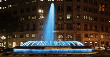 Der Springbrunnen der Allee mit blau beleuchtetem Wasser