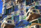 die Frontseite des Casa Batllo mit den Maskenbalkonen und lila und grünen Farben an der Fasada