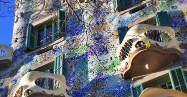 die Frontseite des Casa Batllo mit den Maskenbalkonen und lila und grünen Farben an der Fasada