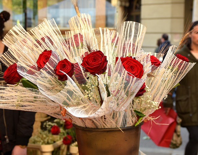 ein Eimer mit einzeln eingepackten roten Rosen