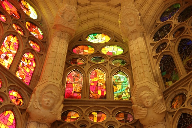 in der Mitte farbige Mosaikfenster und an den weißen Säulen Statuen von Engeln