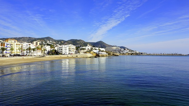 Der Strand von Sitges mit dem Dorf im Hintergrund