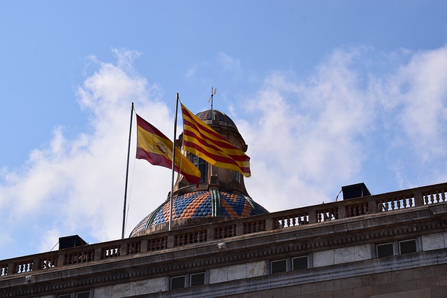 die spanische und die katalanische Fahne auf dem Dach eines Rathauses
