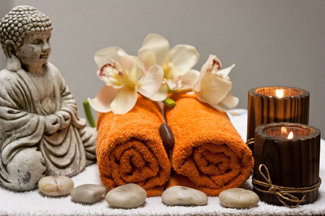 massage in barcelona, buddah, orangene handtücher, weiße orchiedeen, braune kerzen