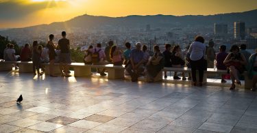 mehrere Leute die einen Sonnenuntergang von einem Aussichtspunkt in Barcelona sehen