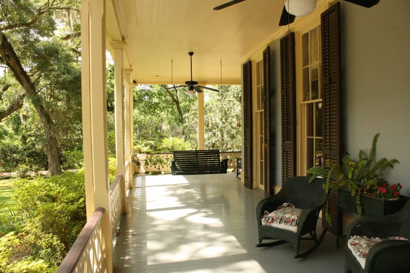 Terrasse eines Ferienhauses mit Sonnenschein und Bäumen im Hintergrund