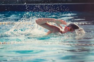 Jugendlicher mit Taucherbrille beim Kraulschwimmen