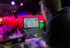 Dj in einer Disco der Musik mit Hilfe eines Laptops auflegt