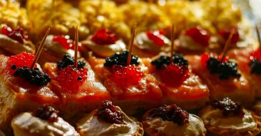 Nahaufnahme verschiedener Tapas und Pintxos mit Gänseleber, Lachs und Kartoffelomlett