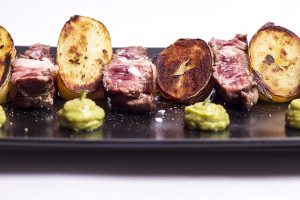schwarzer rechteckiger Teller mit Fleisch Medium, Bratkartoffeln und Guacamole