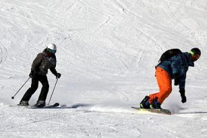 Ein Skifahrer und ein Snowboardfahrer auf der Schneepiste