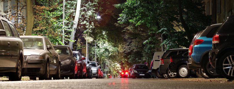 Eine breite Allee mit geparkten Autos auf beiden Seiten