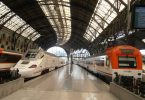 Hauptbahnhof in Barcelona mit zwei Renfe Zügen, einer weiss grau und einer weiss orange