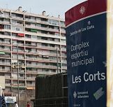 Im Hintergrund Terrassen eines Wohngebäudes und im Vordergrund das Schild vom Sportplatz von Les Corts